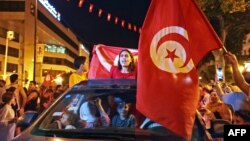 Des centaines de partisans du président ont célébré dqns les rues de Tunis, brandissant le drapeau national.