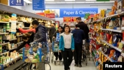 FILE - People shop at a Walmart Supercenter in Toronto, Ontario, Canada, March 13, 2020. Opposition parties in Canada say the government of Prime Minister Justin Trudeau is not doing enough to fight inflation.