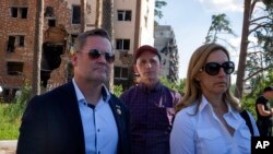 U.S. House Armed Services Committee Chairman Rep. Adam Smith, center, Rep. Mikie Sherrill, right, and Rep. Michael Waltz, look at houses destroyed by Russian shelling in Irpin, on the outskirts of Kyiv, Ukraine, July 23, 2022.