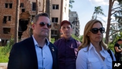 U.S. House Armed Services Committee Chairman Rep. Adam Smith, center, Rep. Mikie Sherrill, right, and Rep. Michael Waltz, look at houses destroyed by Russian shelling in Irpin, on the outskirts of Kyiv, Ukraine, July 23, 2022.