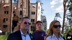 US House Armed Services Committee Chairman Rep. Adam Smith, center, Rep. Mikie Sherrill, right, and Rep. Michael Waltz, R-Fla., look at houses destroyed by Russian shelling in Irpin, on the outskirts of Kyiv, Ukraine, July 23, 2022.