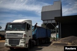 A truck driver secures the load under grain elevator, at the grain storage facility of Vitalii Kistrytsya, as Russia's attack on Ukraine continues, in Dnipropetrovsk region, Ukraine, July 30, 2022.