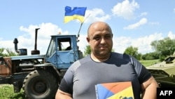 Viktor Kychuk, 44, attends an event dedicated to the release of the latest military-themed Ukrainian stamps called "Good evening, we are from Ukraine!" on a field near the village of Mala Rogan, Kharkiv region, on July 28, 2022.
