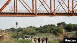 Migrantes que buscan asilo son escoltados por agentes de la Guardia Nacional después de cruzar el río Grande hacia EEUU desde México en Eagle Pass, Texas, el 12 de julio de 2022. REUTERS/Go Nakamura