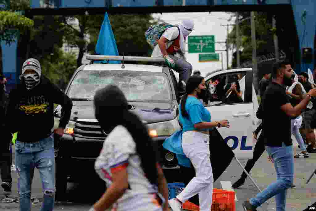 Un grupo de manifestantes ocupa un auto de la policía durante una protesta por el alto costo de los alimentos y la gasolina en Ciudad de Panamá, el 11 de julio de 2022.