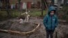 У дворі їхнього будинку 6-річний Влад Танюк стоїть біля могили своєї матері Марини Танюк, яка померла від голоду та стресу через війну, на околиці Києва, Україна, понеділок, 4 квітня 2022 р. ( AP Photo/Rodrigo Abd)