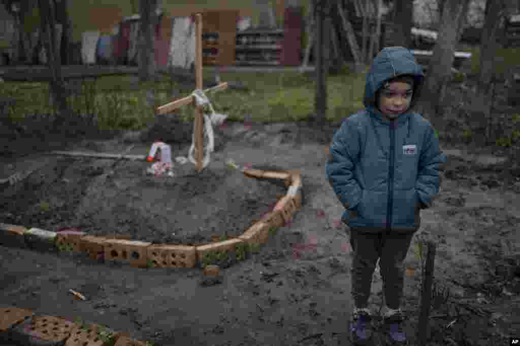 6-летний Влад&nbsp;стоит у могилы своей матери,&nbsp;погибшей в Буче под Киевом. 4 апреля 2022 года (АР)