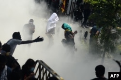 Tentara Sri Lanka (tidak terlihat) menggunakan gas air mata untuk membubarkan demonstran selama protes anti-pemerintah di luar kantor perdana menteri Sri Lanka di Kolombo pada 13 Juli 2022. (Arun SANKAR / AFP)