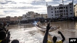 Les supporters assistent au dévoilement de la pirogue de leurs équipes dans le village de pêcheurs de Guet N'Dar à Saint-Louis le 23 juillet 2022.