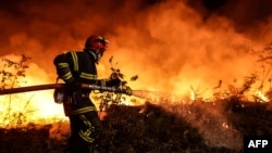 Seorang petugas berupaya memadamkan api kebakaran hutan di dekat Louchats, Gironde, Prancis barat daya, 17 Juli, 2022. (THIBAUD MORITZ / AFP)