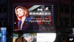 People walk past a billboard welcoming U.S. House Speaker Nancy Pelosi, in Taipei, Taiwan, Aug 2, 2022. 