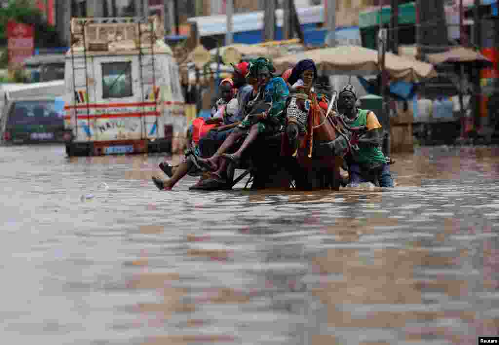 Residents make their way through a flooded street after heavy rains in the&nbsp; Yoff district of Dakar, Senegal, July 20, 2022.