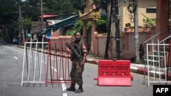 A member of the Myanmar security forces stands by a checkpoint in Yangon on July 19, 2022, on the 75th Martyrs' Day that marks the anniversary of the assassination of independence leaders including general Aung San, father of the currently deposed and imp