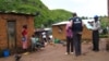 FILE - World Health Organization epidemic specialists visit a shanty town after an outbreak of the Marburg virus in Angola, April 10, 2005, in Uige. The disease has been found for the first time in West Africa.