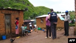 FILE - World Health Organization epidemic specialists visit a shanty town after an outbreak of the Marburg virus in Angola, April 10, 2005, in Uige. The disease has been found for the first time in West Africa.