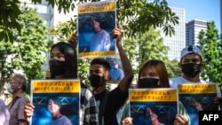 Sekelompok aktivis memegang plakat bergambar warga negara Jepang Toru Kubota, yang ditahan di Myanmar, dalam aksi unjuk rasa di depan Kementerian Luar Negeri di Tokyo, 31 Juli 2022. (Philip FONG / AFP)