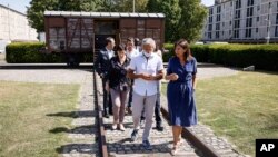 FILE - Paris mayor Anne Hidalgo talks to Jacques Fredj, head of the Shoah Memorial, as they leave the train car symbolizing the Drancy camp, at the Shoah memorial, July 12, 2022 in Drancy, outside Paris.