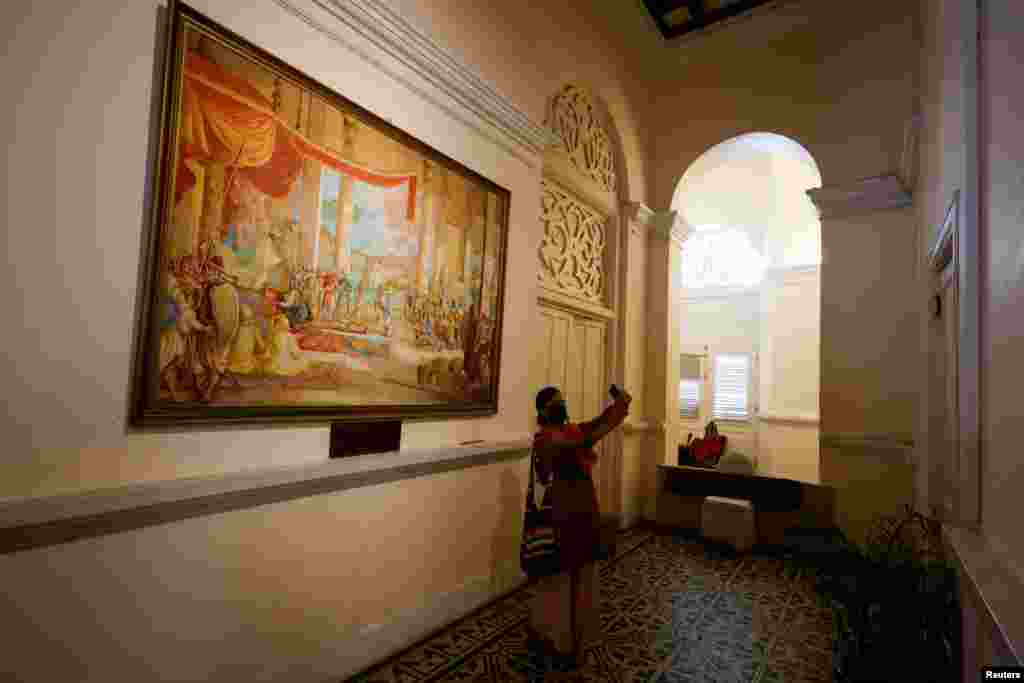A woman takes a selfie in front of a painting inside the President's house after President Gotabaya Rajapaksa fled, amid the country's economic crisis, in Colombo, Sri Lanka, July 13, 2022.