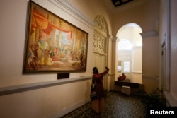 A woman takes a selfie in front of a painting inside the President's house after President Gotabaya Rajapaksa fled, amid the country's economic crisis, in Colombo, Sri Lanka, July 13, 2022.