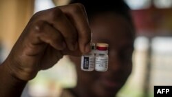 FILE — A nurse shows the Malaria vaccine Mosquirix at the Ewin Polyclinic in Cape Coast, Ghana, on April 30, 2019. 