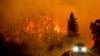 Sebuah mobil pemadam kebakaran tampak melintas di jalan raya besar California 96 di tengah kebakaran McKinney yang melanda wilayah Klamath National Forest, California, pada 30 Juli 2022. (Foto: AP/Noah Berger)