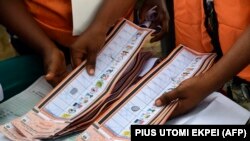 Un agent électoral tient des bulletins de vote dépouillés dans un bureau de vote lors de l'élection du gouverneur dans l'État d'Osun, dans le sud-ouest du Nigeria, le 16 juillet 2022. 