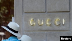 People stand in front of a Gucci luxury brand store on Avenue Montaigne in Paris, France, July 13, 2022. REUTERS/Rali Benallou