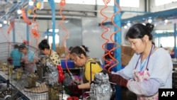 A worker produces miniature tillers at a factory in China's southwestern Chongqing, July 29, 2022. 