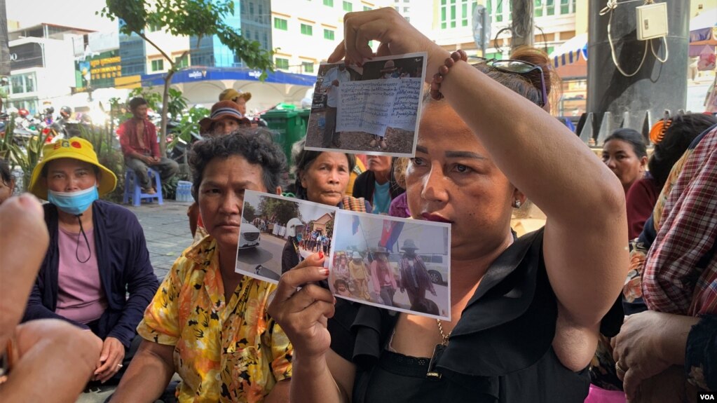 អ្នកស្រី ប្រាក់ សុភា លើករូបភាពជាភ័ស្តុតាងបង្ហាញអ្នកសារព័ត៌មាន នៅខាងមុខតុលាការក្រុងភ្នំពេញ ថ្ងៃទី០២ ខែសីហា ឆ្នាំ២០២២។ (លាស់ លីបលីប/វីអូអេ)