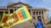 FILE - A man wears a headband with a slogan against interim Sri Lankan President Ranil Wickremesinghe as he waves the Sri Lankan national flag near the Presidential secretariat in Colombo, July 17, 2022. 