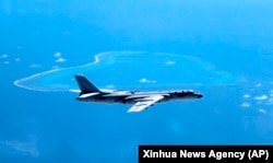 In this undated file photo released by Xinhua News Agency, a Chinese H-6K bomber patrols the islands and reefs in the South China Sea.