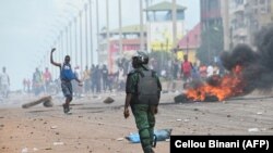FILE:A police officer looks on as protesters block roads and hurl rocks in Conakry on July 28, 2022, after authorities prevented supporters of the opposition party, National Front for the Defence of the Constitution (FNDC), from gathering in the streets for a peaceful march