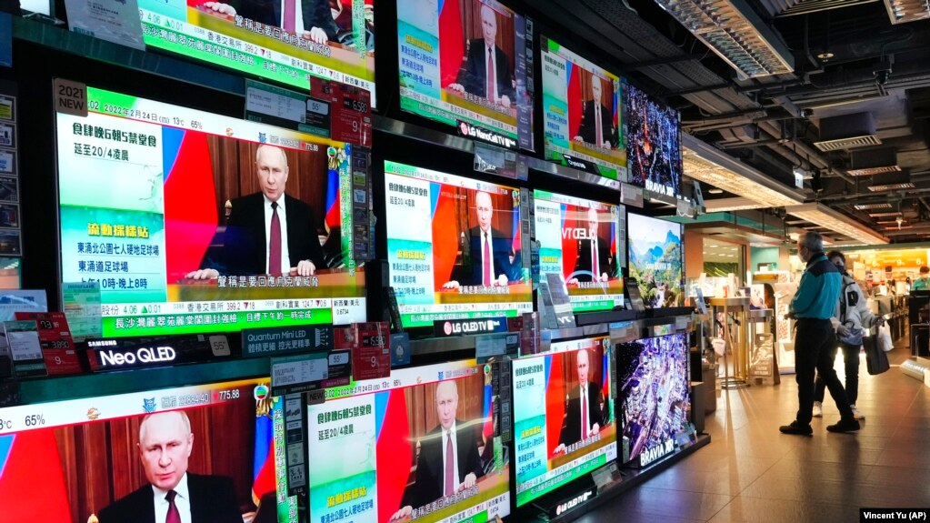 资料照片：在香港一家商场内，人们站在电视屏幕前观看俄罗斯全面入侵乌克兰的新闻。（2022年2月24日）(photo:VOA)