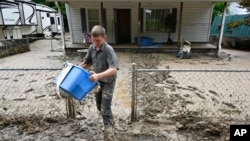 Members of the local Mennonite community remove mud-filled debris from homes following flooding at Ogden Hollar in Hindman, Ky., July 30, 2022. 