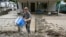 Members of the local Mennonite community remove mud-filled debris from homes following flooding at Ogden Hollar in Hindman, Ky., July 30, 2022. 
