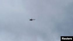 A military helicopter flies over the main military base after heavy gunfire was heard early on Friday, in Kati, outside the capital Bamako, Mali, July 22, 2022. 