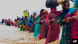 Petugas penyelamat membantu warga mengungsi dari daerah banjir akibat hujan lebat, di Lasbella, sebuah distrik di Provinsi Baluchistan barat daya Pakistan, Selasa, 26 Juli 2022. (AP/Hamdan Khan)