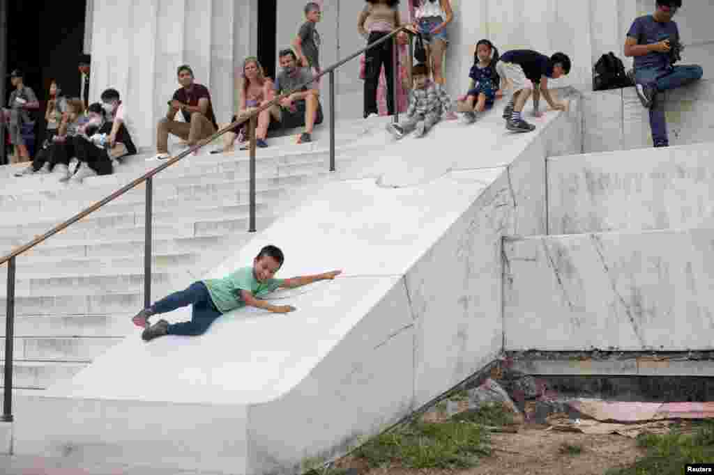 James Vongue, 8, slides down a marble structure at the Lincoln Memorial in Washington, July 31, 2022.