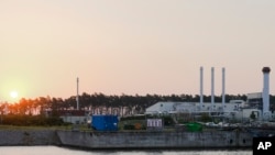 FILE - The sun rises behind the landfall facility of the Nord Stream 1 Baltic Sea pipeline and the transfer station of the OPAL gas pipeline, the Baltic Sea Pipeline Link, in Lubmin, Germany, July 21, 2022. 