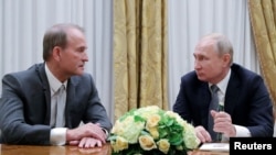 FILE - Russia's President Vladimir Putin (R) attends a meeting with leader of Ukraine's Opposition Platform - For Life party Viktor Medvedchuk in Saint Petersburg, Russia July 18, 2019.