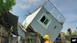 Rescatistas revisan la pared de una casa dañada después de un fuerte terremoto en la provincia de Ilocos Sur, Filipinas, el miércoles 27 de julio de 2022. (Oficina de Protección contra Incendios vía AP)