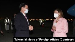 台湾外交部长吴钊燮（左）在台北松山机场迎接美国会众议院议长佩洛西。（2022年8月2日）