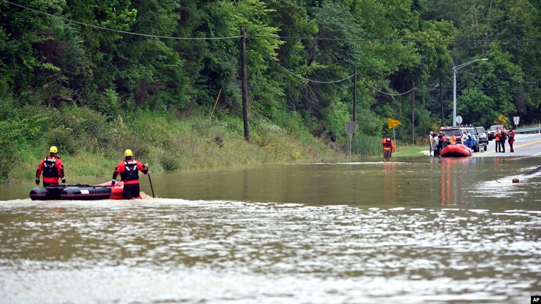 Bomberos de Winchester, Kentucky., se desplazan en botes inflables a través de las aguas de la inundación sobre la carretera estatal 15 en Jackson, Kentucky., para recoger a personas varadas por las aguas de la inundación el jueves 28 de julio de 2022. (Foto AP/Timothy D. fácil)