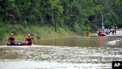 Bomberos de Winchester, Kentucky., se desplazan en botes inflables a través de las aguas de la inundación sobre la carretera estatal 15 en Jackson, Kentucky., para recoger a personas varadas por las aguas de la inundación el jueves 28 de julio de 2022. (Foto AP/Timothy D. fácil)
