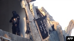 ​ແຟ້ມ - ນັກ​ລົບ​ຄົນ​ນຶ່ງ​ຂອງ​ກຸ່ມ​ກໍ່​ການ​ຮ້າຍ​ອາ​ລ​ກາ​ອີ​ດາ ທີ່ Levant, Al-Nusra Front ຢືນ​ຍາມ​ຢູ່​ຕຶກ​ອາ​ຄານ​ທີ່​ຖືກ​ທຳ​ລາຍ​ຫຼັງ​ນຶ່ງ ໃນ​ສູນ​ອົບ​ພະ​ຍົບ​ປາ​ແລ​ັ​ສ​ໄຕ​ນ໌ Yarmuk ​ທາງ​ໃຕ້​ນະ​ຄອນ​ຫຼວງ​ດາ​ມາ​ສ​ກັ​ສ ເມື່ອ​ວັນ​ທີ 22 ກັນ​ຍາ 2014. 