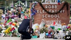 یادبودی در مقابل تابلوی دبستان راب در شهر یوالده ایالت تگزاس برای از دست رفتگان در حمله مسلحانه به این مدرسه- آرشیو