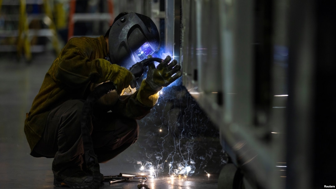 FILE: A welder works while building a bus frame at the BYD electric bus factory in Lancaster, California, on July 1, 2021.
