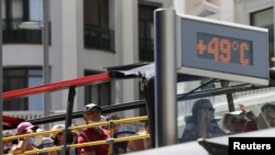 FILE: A tourist bus rides past a thermometer displaying 49 Celsius degrees (120.2 Fahrenheit degrees) at Gran Via during the second heatwave of the year in Madrid, Spain, July 15, 2022.