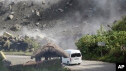 ফিলিপাইনের পার্বত্য প্রদেশ বাউকোতে ভূমিকম্পের সময় একটি গাড়ি রাস্তা দিয়ে যাওয়ার সময় পাথরের বোল্ডার ভেঙ্গে পড়ে। ২৭ জুলাই ২০২২।