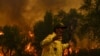 Un pompier réagit alors qu'il tente d'éteindre un incendie de forêt causé par des températures extrêmes à Larache, dans le nord du Maroc, le 15 juillet 2022.